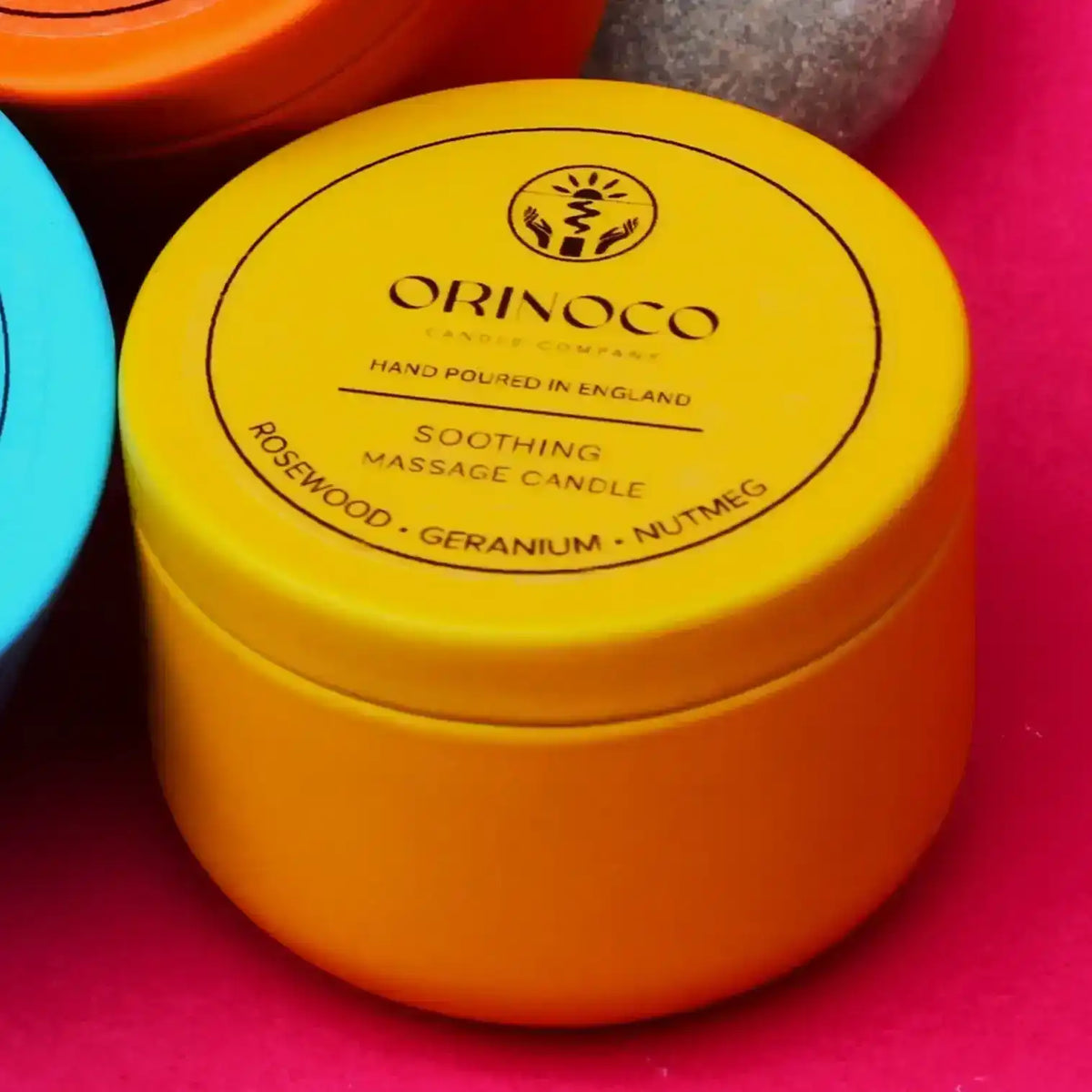 Orinoco Soothing Massage Candle with Rosewood, Geranium, and Nutmeg in a yellow tin.