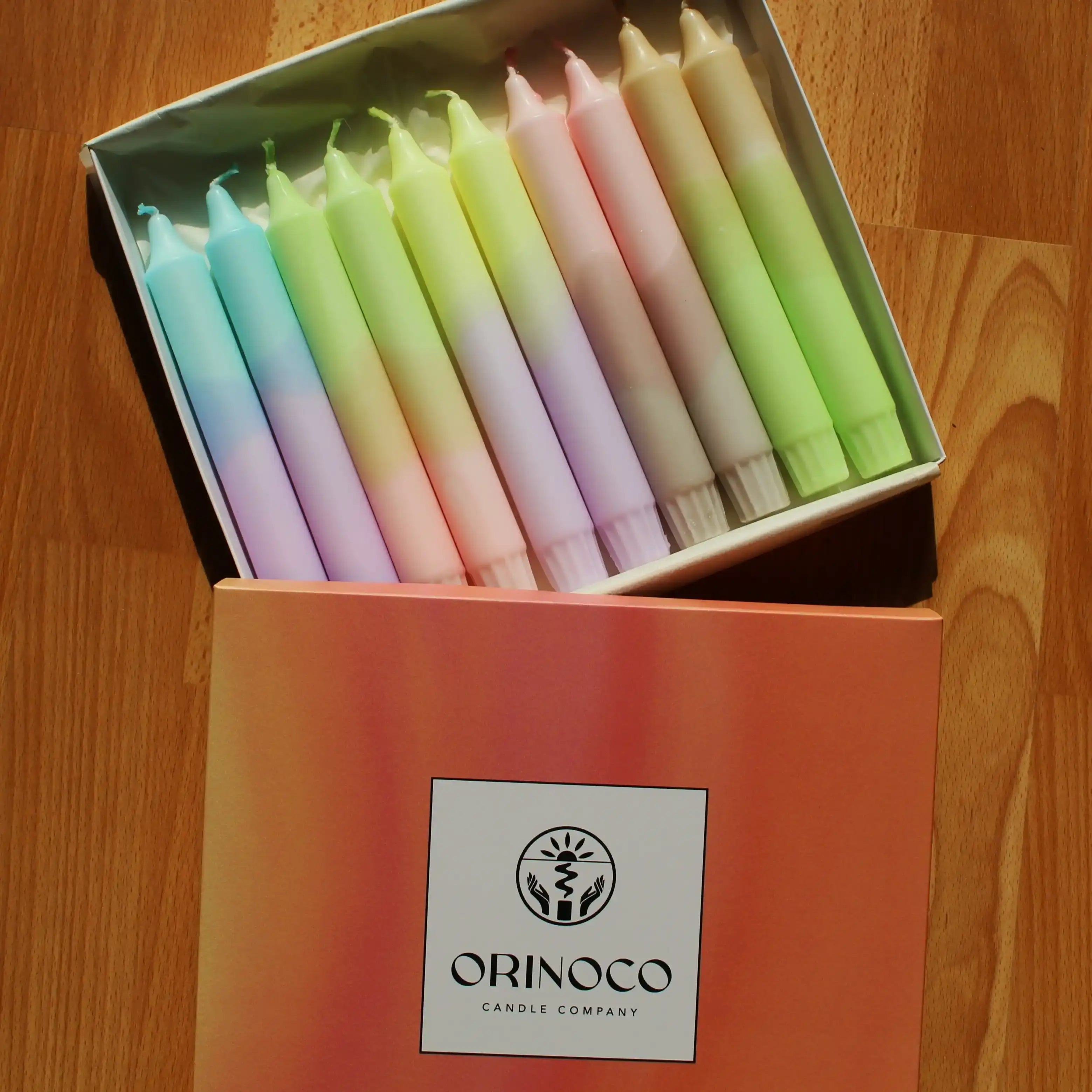 Set of colorful pastel tapered candles in an Orinoco Candle Company gift box.
