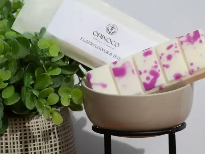 Orinoco Skincare Elderflower & Iris soap bar with purple swirls in a beige bowl.