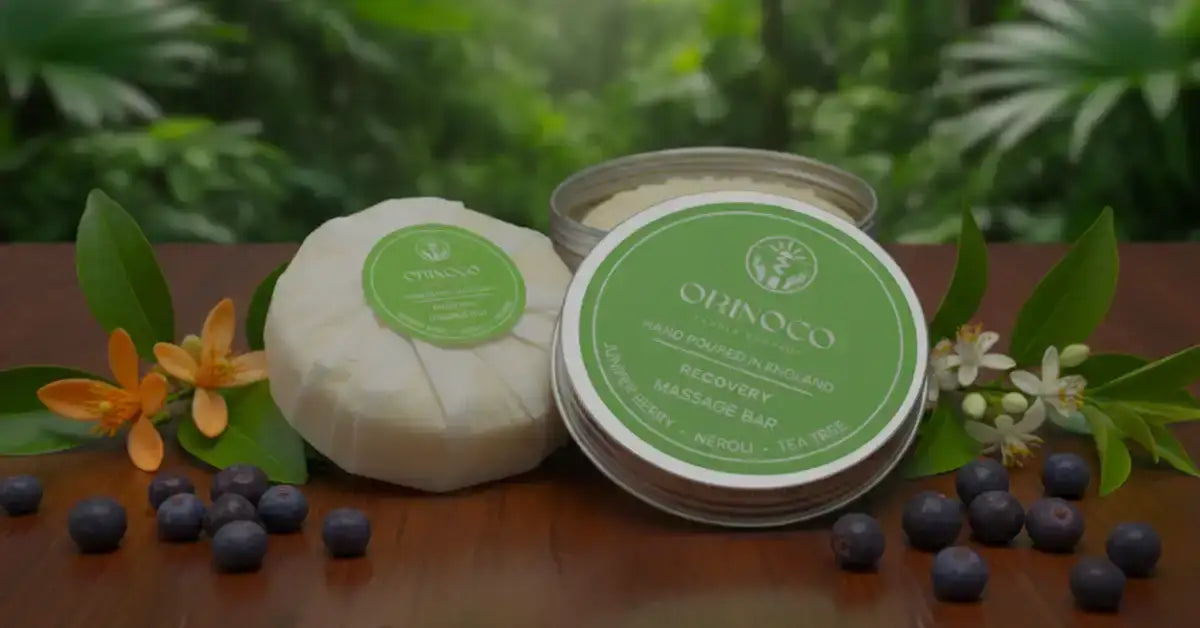 Orinoco Recovery Massage Bar in a tin and wrapped soap with blueberries and tropical leaves.
