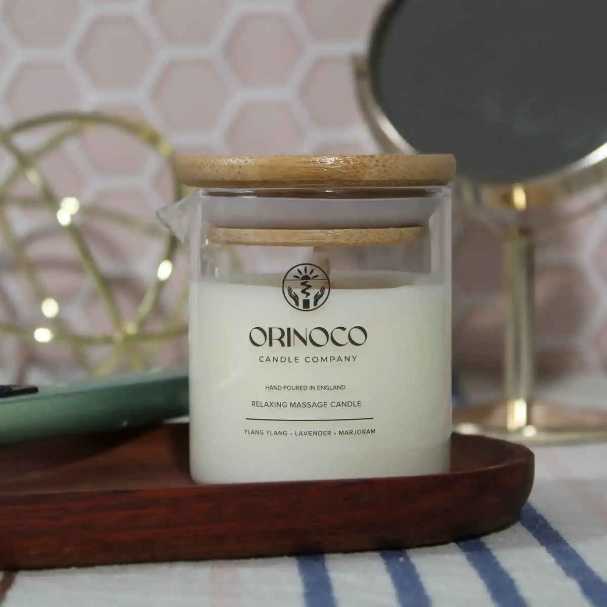 Orinoco Candle Company relaxing massage candle with wooden lid on a wooden tray.