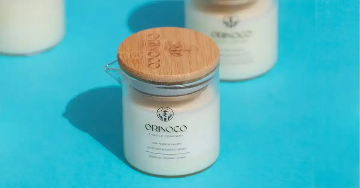 Orinoco Candle Company soothing massage candle with a wooden lid on a blue background.