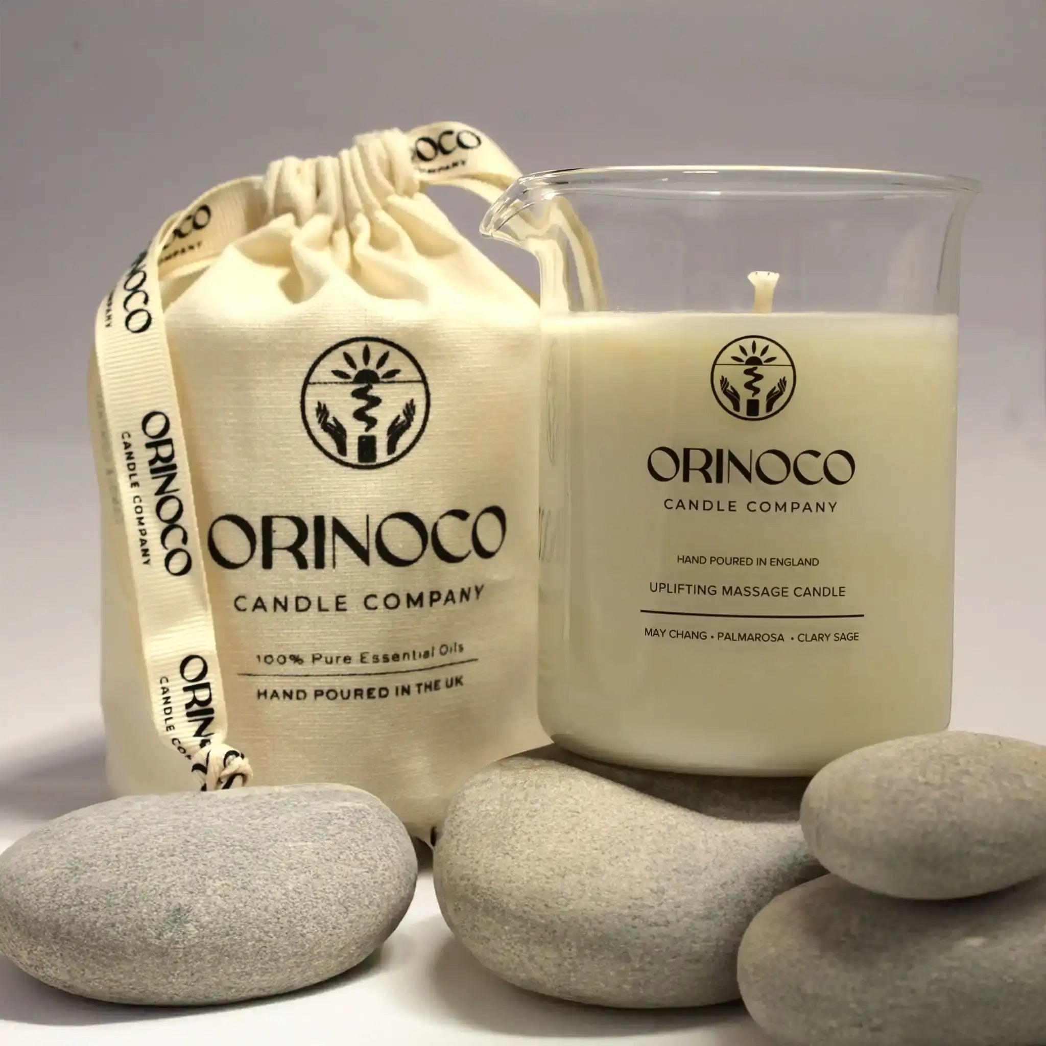 Orinoco Candle Company uplifting massage candle in a glass jar with a cream fabric pouch.