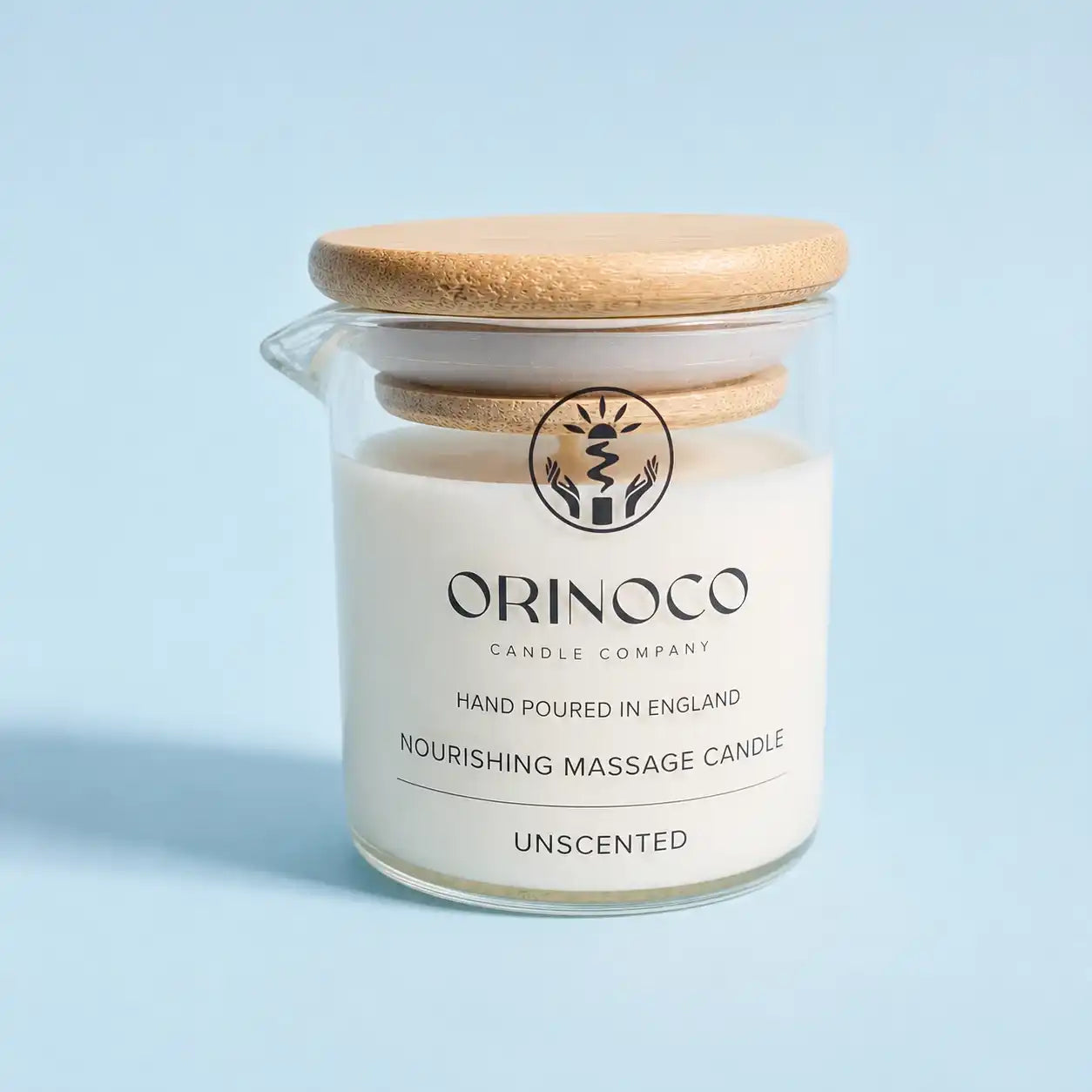 Orinoco Skincare unscented nourishing massage candle in a glass jar with a bamboo lid.