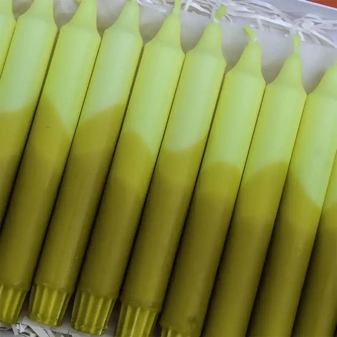 Row of lime green and pale yellow gradient taper candles