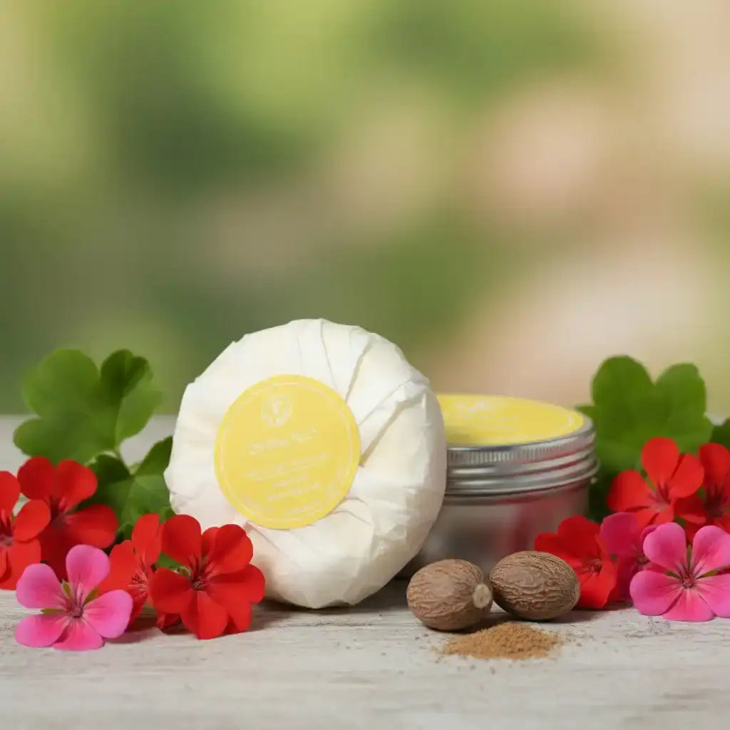 Natural therapeutic skincare balm in a white wrapped package and silver tin with red flowers.
