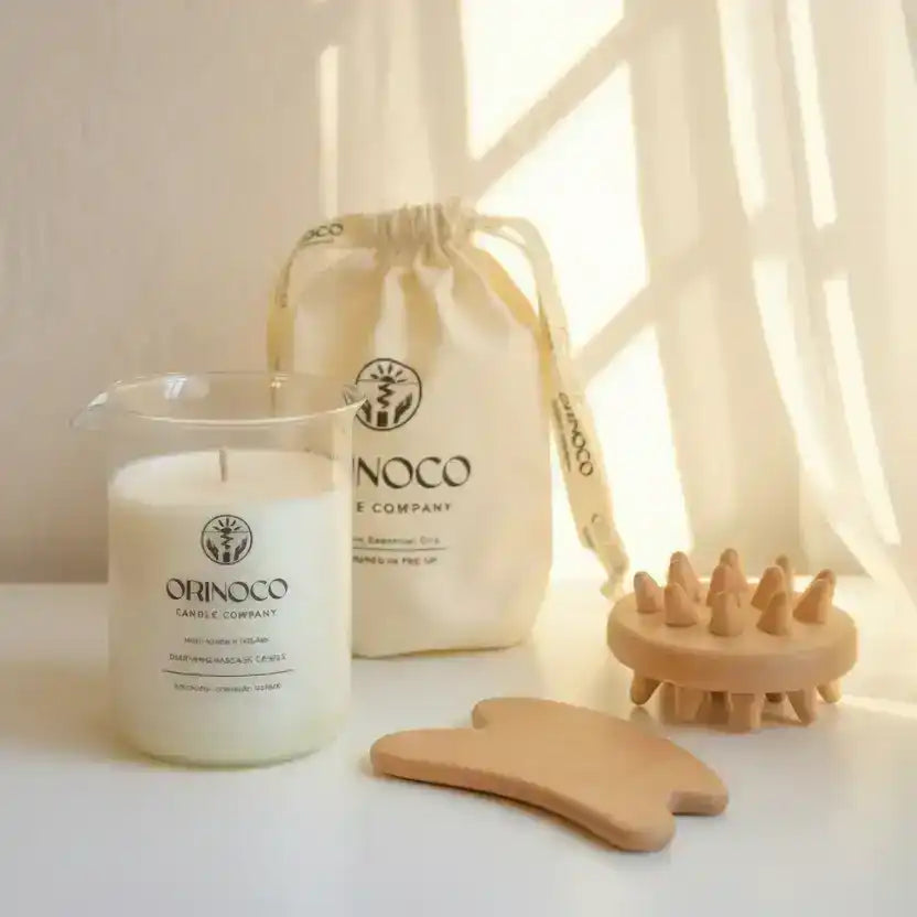 Orinoco Skincare massage candle, drawstring pouch, and wooden massage tools on a white surface.