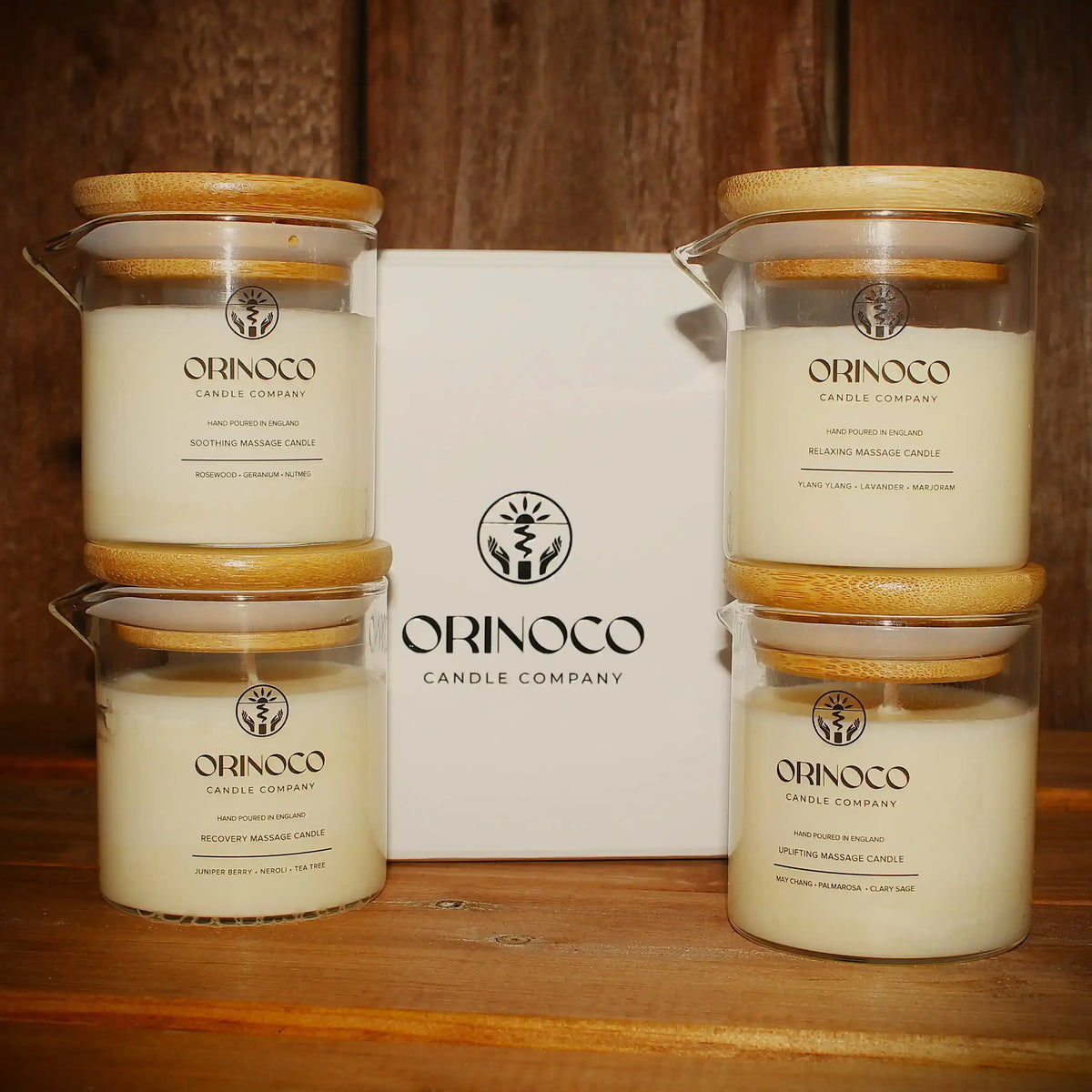 Four Orinoco Candle Company massage candles with bamboo lids and a white gift box.