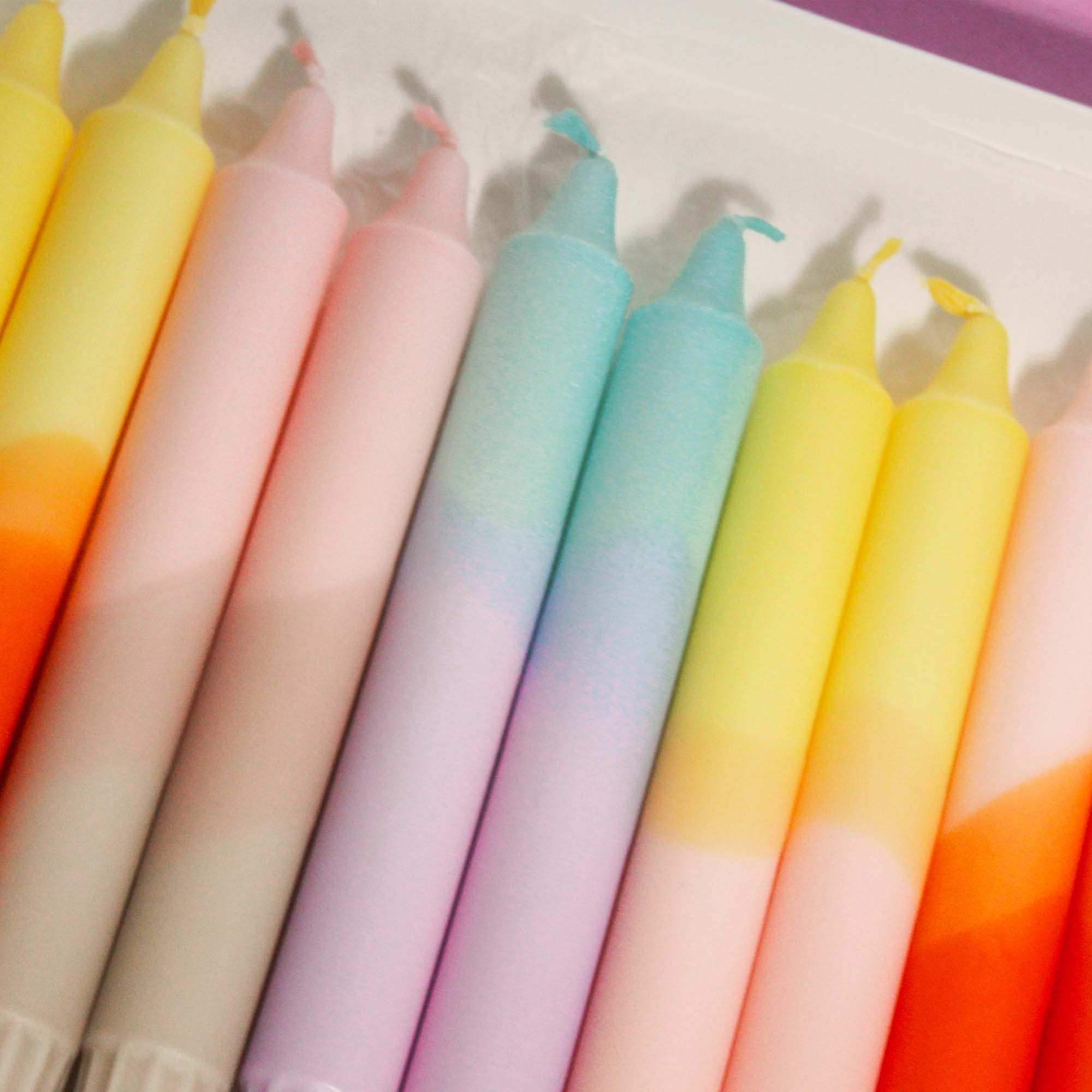 Set of colorful pastel gradient taper candles in various shades of pink, blue, and yellow.