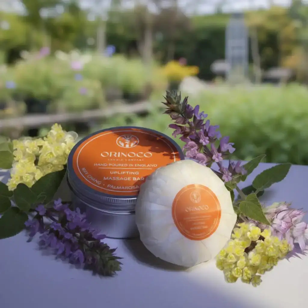 Orinoco Uplifting Massage Bar with purple and yellow flowers in a garden setting.